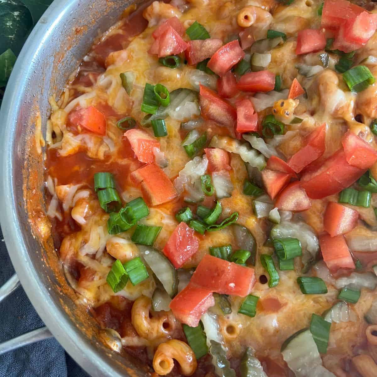 Easy One-Pot Cheeseburger pasta is ready in under 30 minutes. The noodles cook in the same pan with all the other ingredients and then you can top it off with your favorite burger toppings.