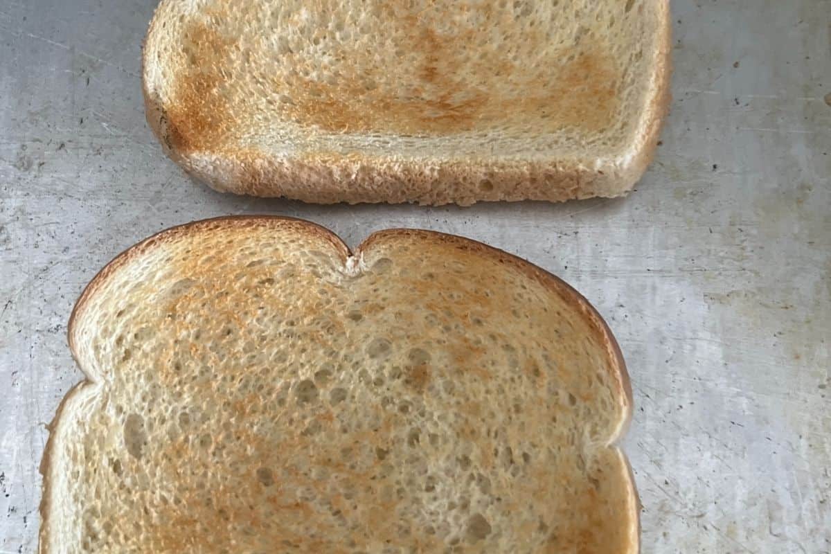 Toasted bread on baking sheet. 