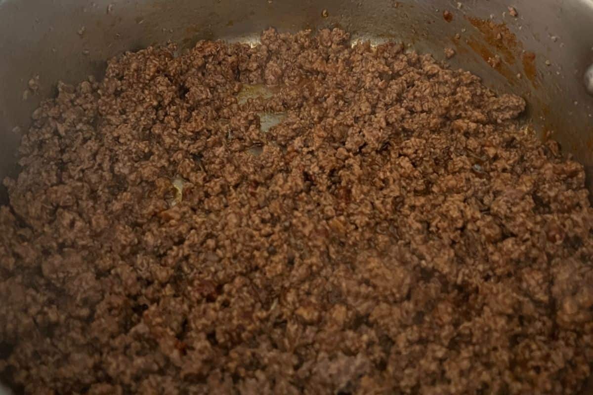 Ground beef seasoned with taco seasoning cooking in a skillet. 