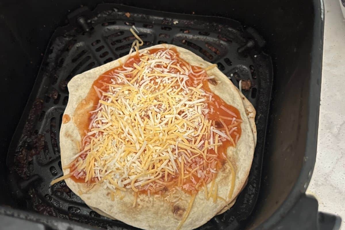 Mexican pizza topped with enchilada sauce and cheese. 