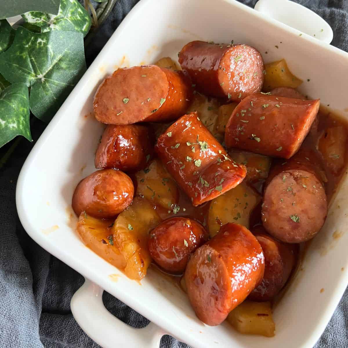 Slow cooker sausage and pineapple is a delicious dish made by combining savory sausage links with sweet pineapple chunks in a slow cooker. 