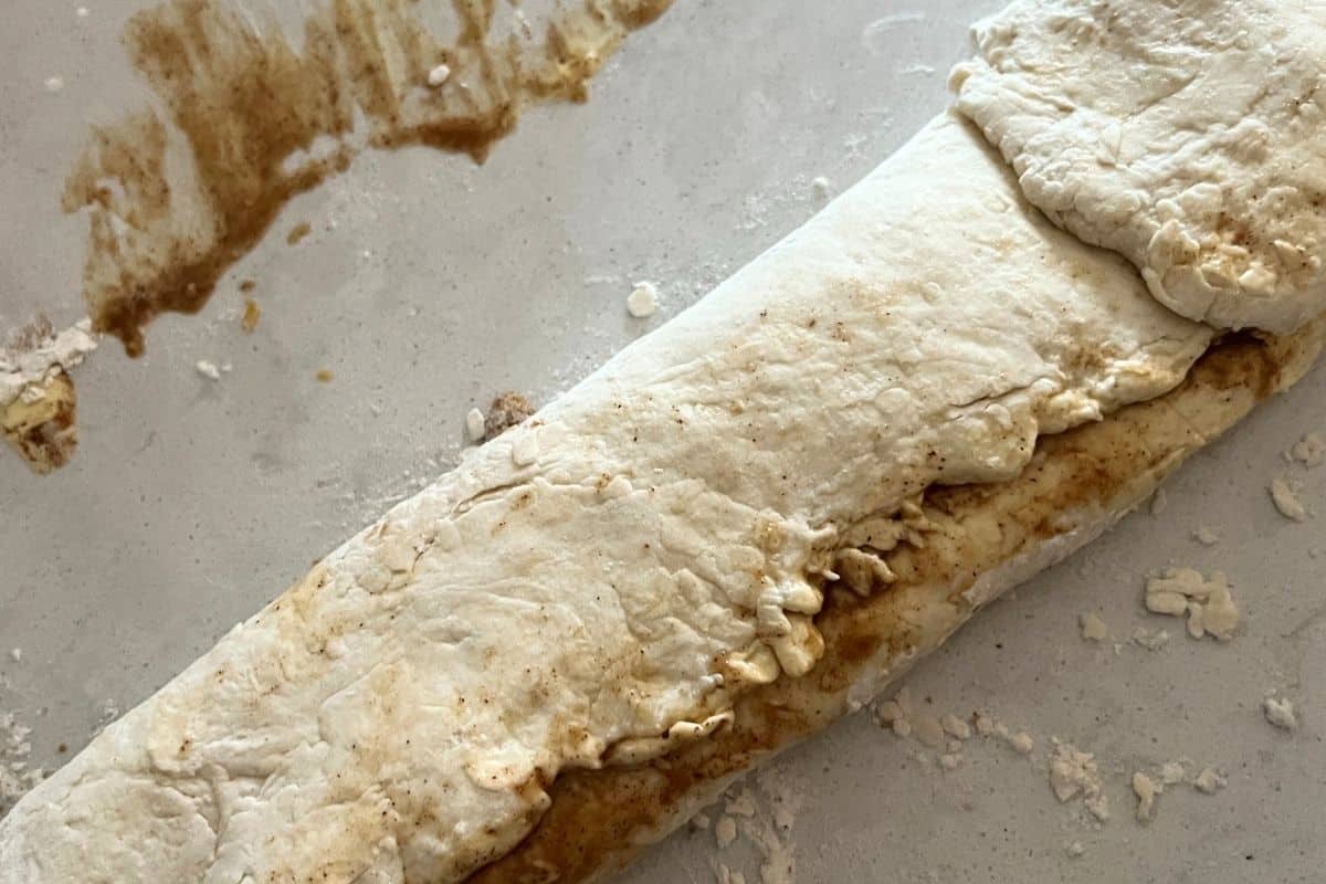 Folded cinnamon roll dough  ready to be cut. 
