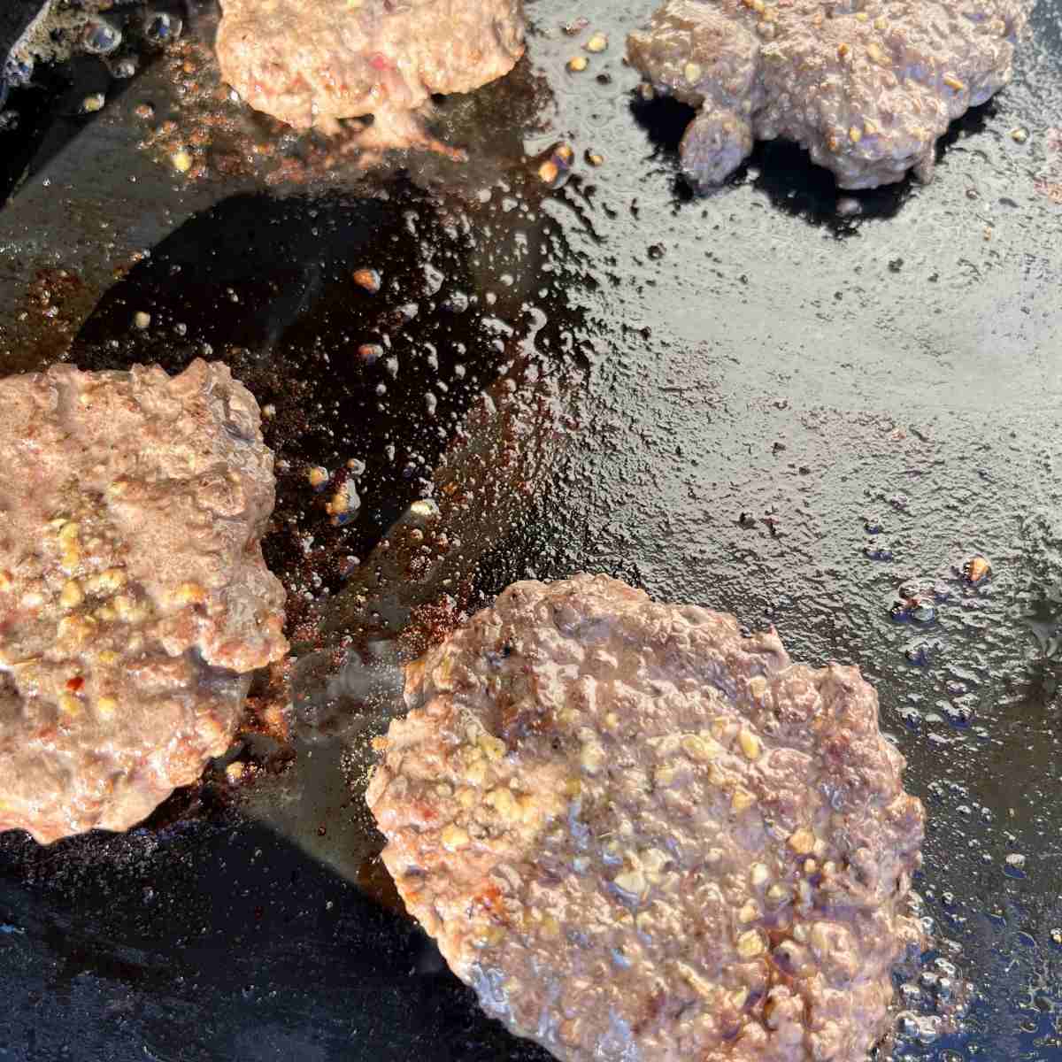 Cooked burgers on Blackstone griddle. 
