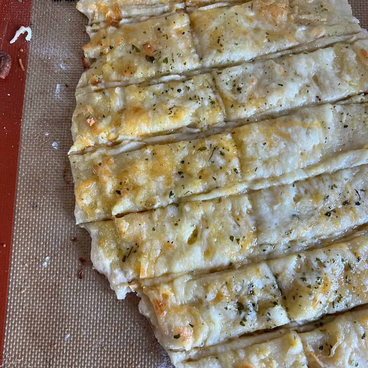 These Easy Cheesy Garlic Breadsticks are made with the famous 2 ingredient dough! Some call it 2 Ingredient Dough or Protein Dough cause it's made with equal parts Greek Yogurt and Self Rising Flour. 