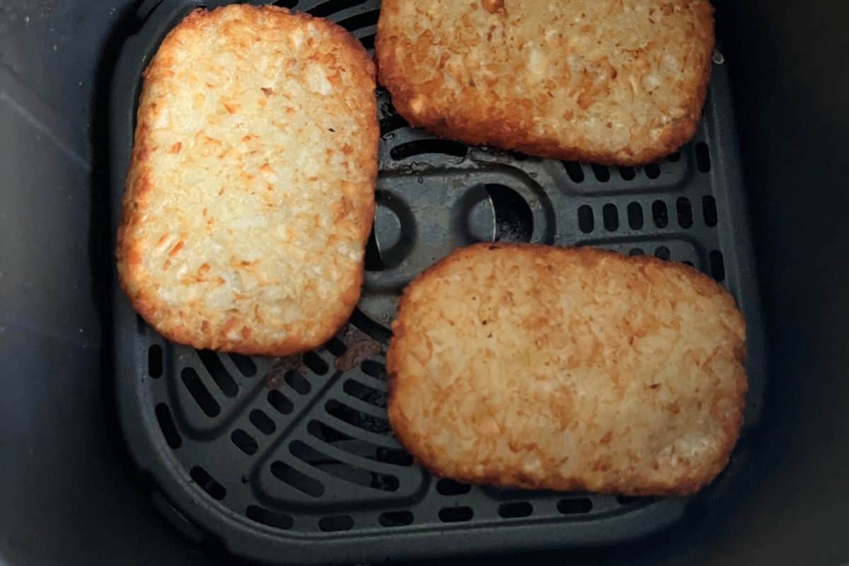 Cooked hash brown patties in air fryer.