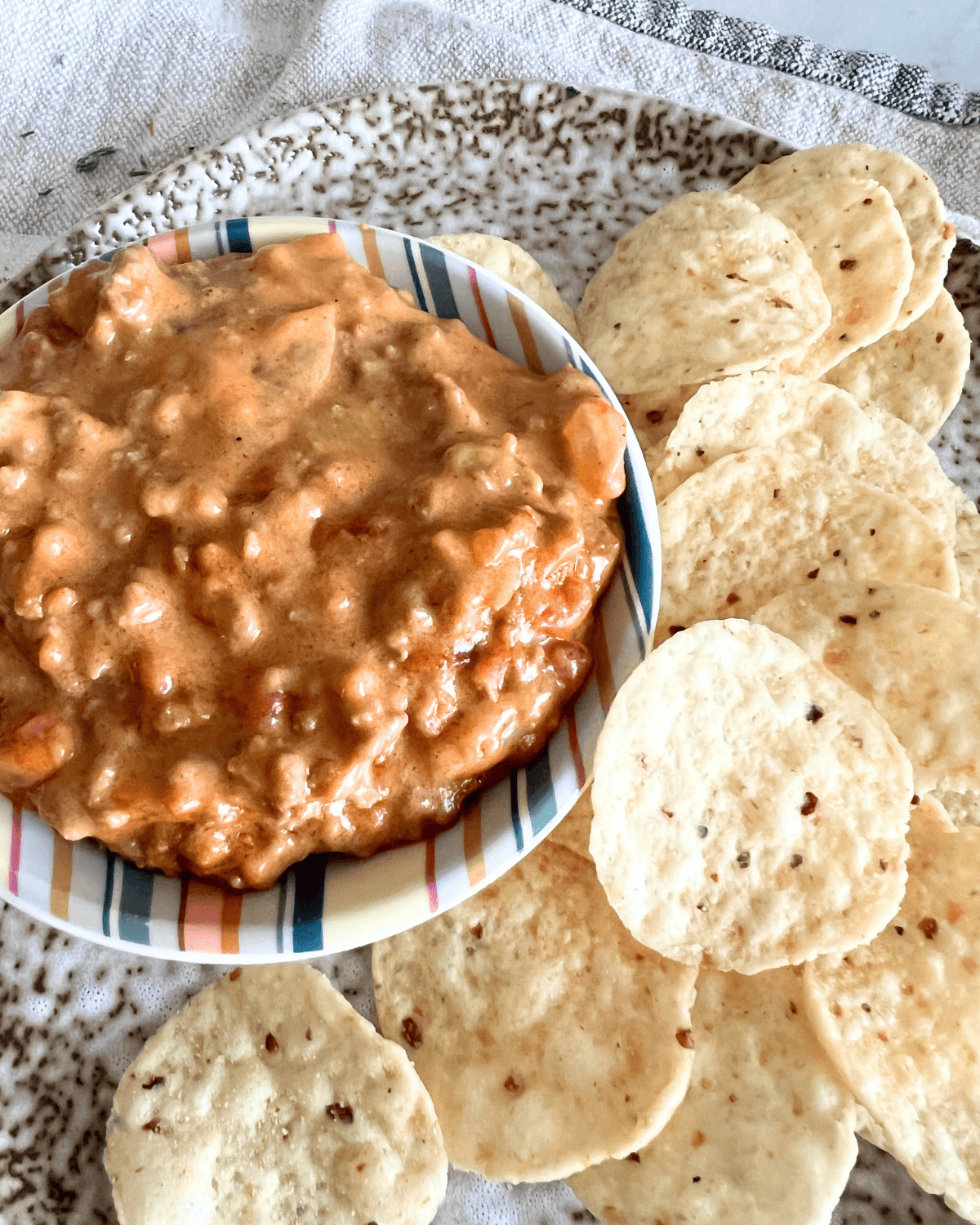 Smoked queso dip on a plate next to chips.
