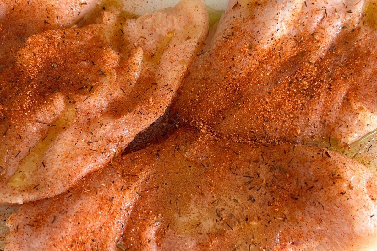 Seasoned chicken breasts ready for griddle.