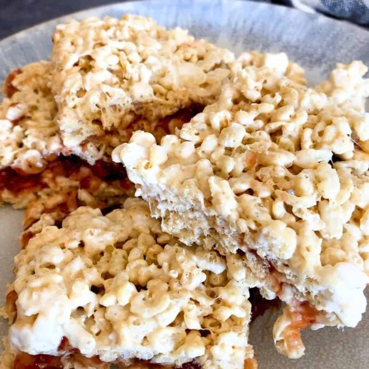 Peanut Butter and Jelly Rice Krispie Treats on a blue plate.
