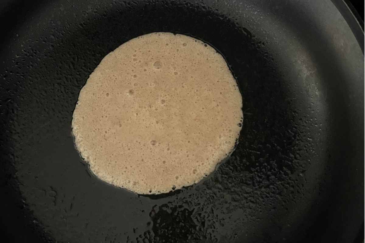 Egg white pancakes cooking in a pan.