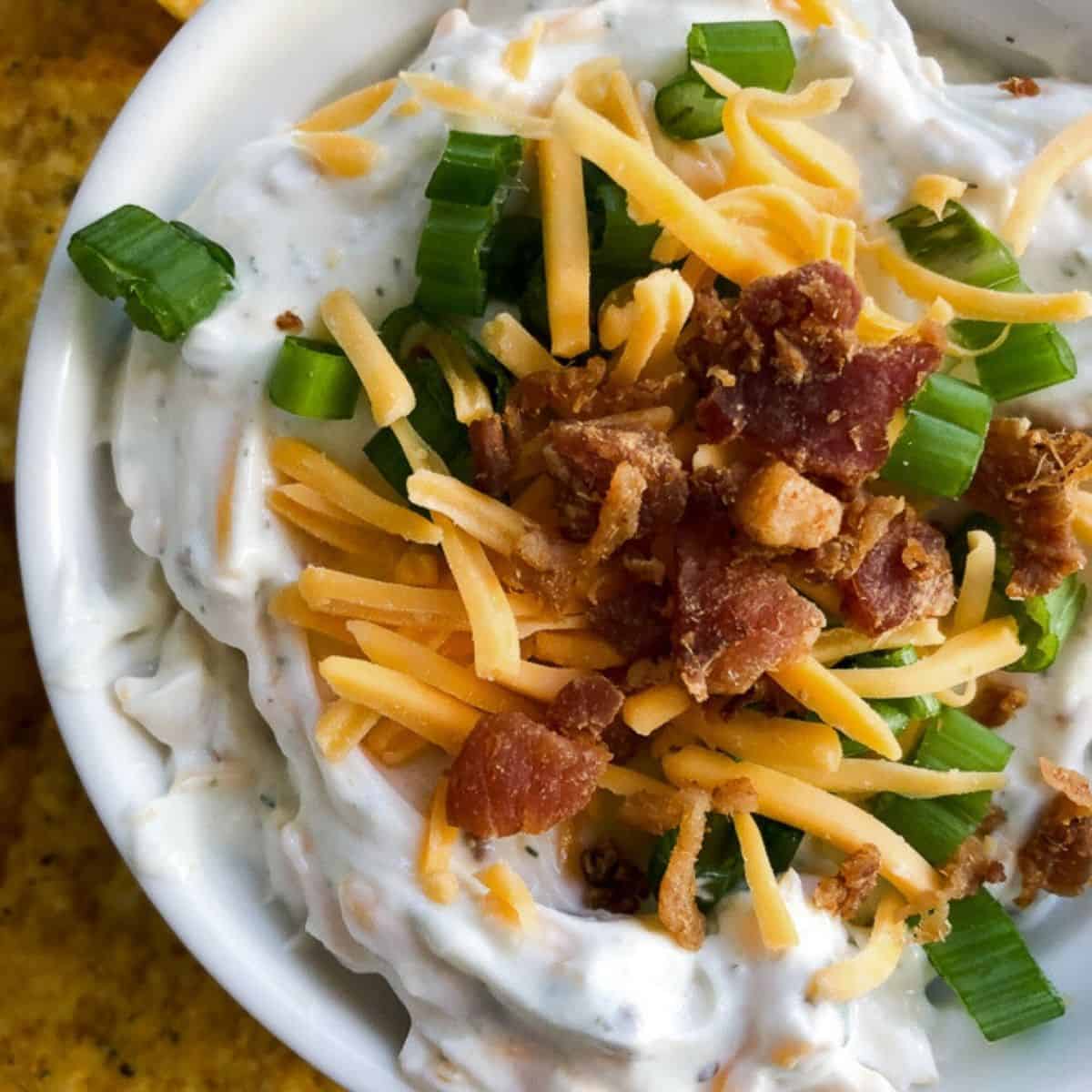 Crack dip topped with extra cheese, bacon, and green onions.