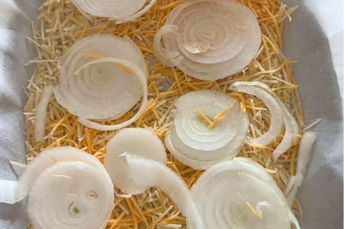Onions and cheddar arranged on a baking sheet.