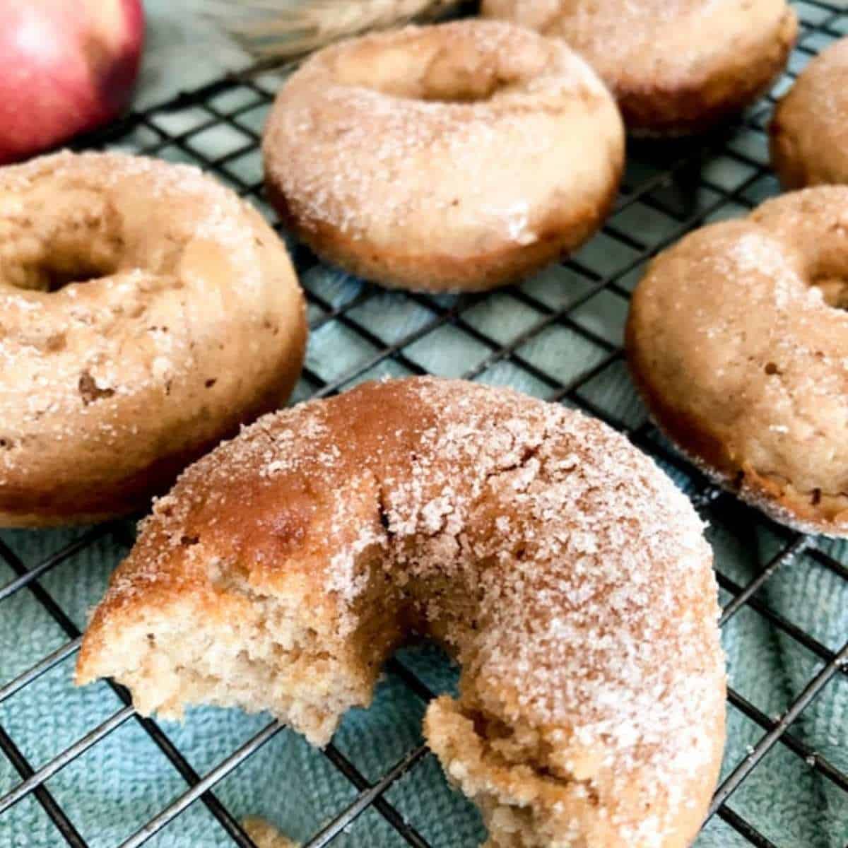 Baked apple cider donuts cooling on a rack.