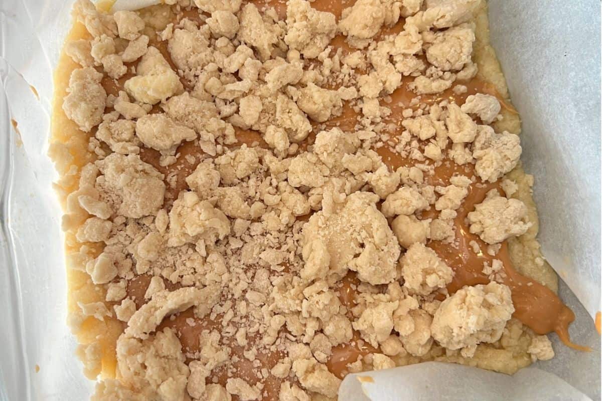 Crumbled shortbread topping on top of caramel bars.