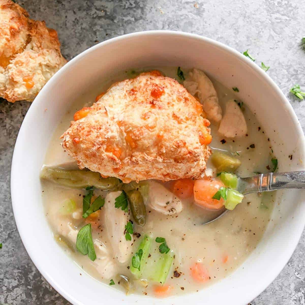 Chicken pot pie soup served in a white bowl.