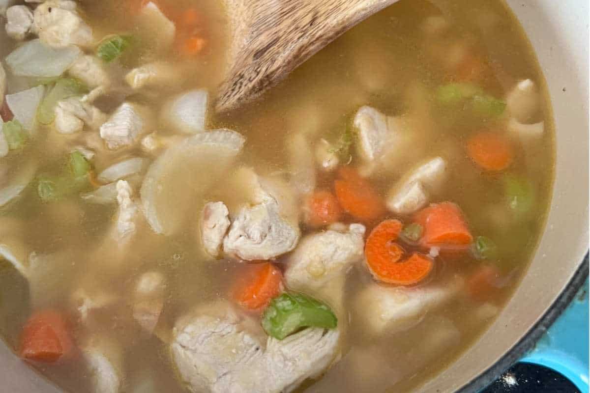 Chicken broth mixed in a pot.