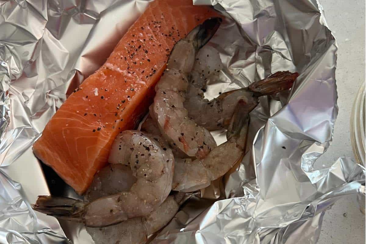 Seasoned salmon and shrimp wrapped in foil.