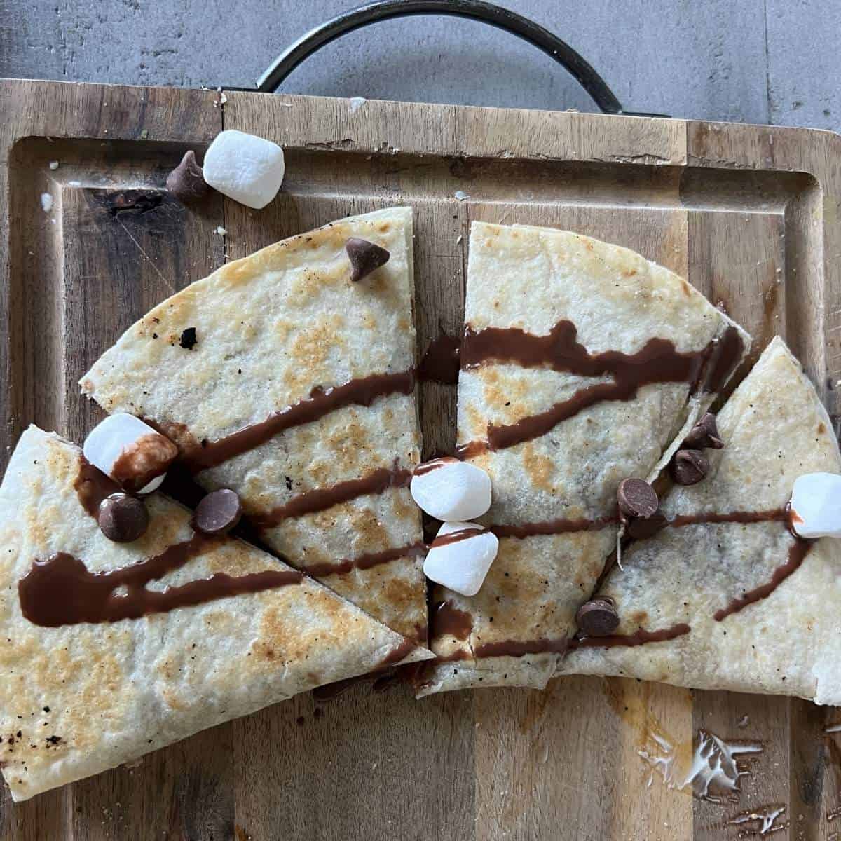 S'more quesadilla topped with melted chocolate and marshmallows.
