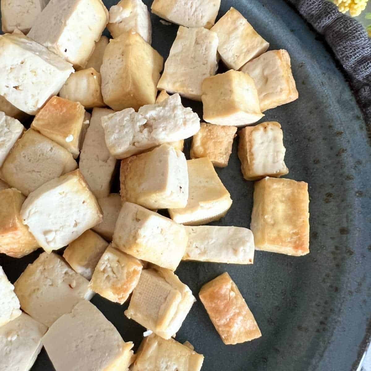 Crispy air fryer tofu on a blue plate.