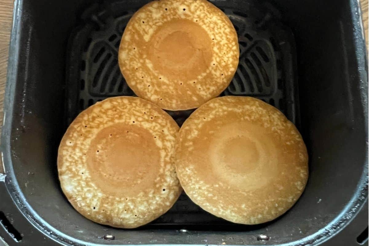Frozen pancakes in air fryer in a single layer.