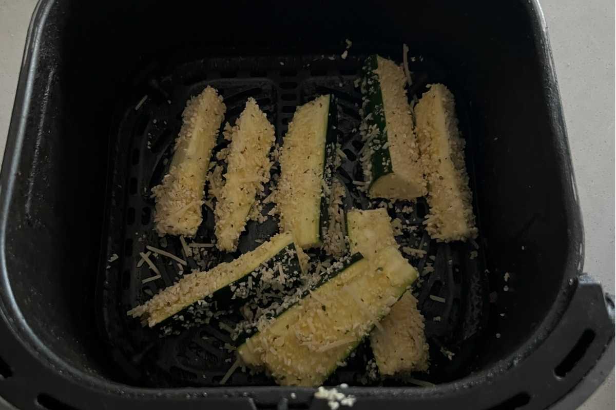 Dipped zucchini fries in egg and bread crumbs in air fryer basket.