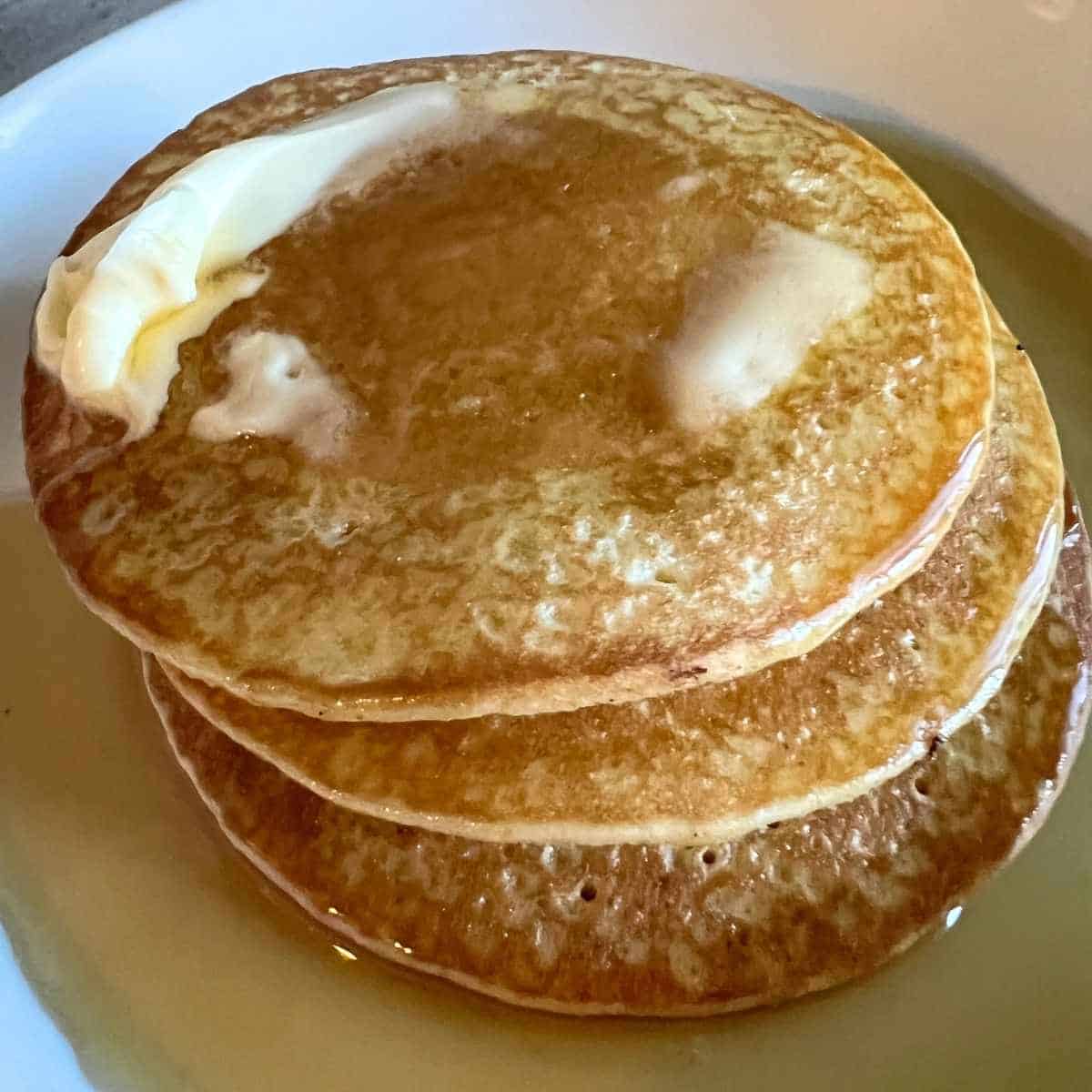 Fluffy Air fryer frozen pancakes topped with butter and maple syrup.