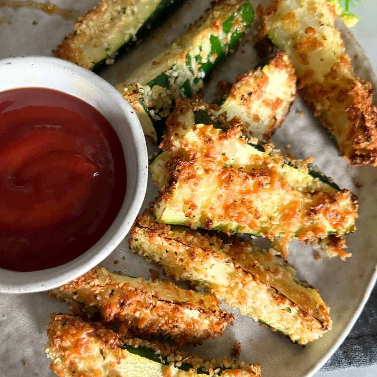 Crispy and golden air fryer zucchini fries with ketchup.