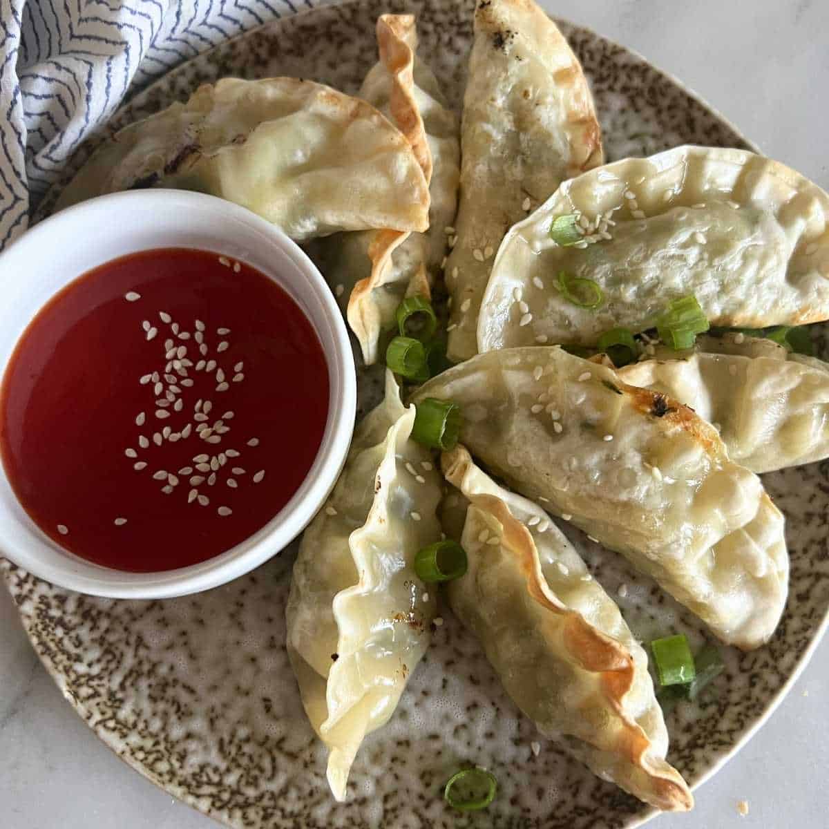 Air fried potstickers served with sweet and sour sauce.