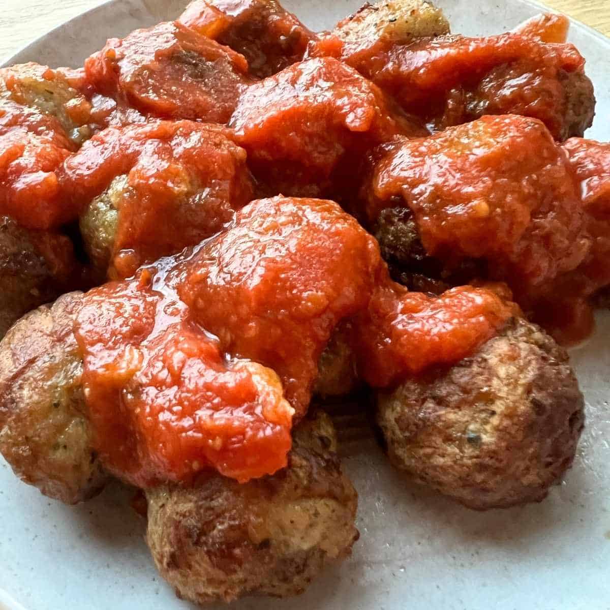 Air fried meatballs topped with marinara sauce.