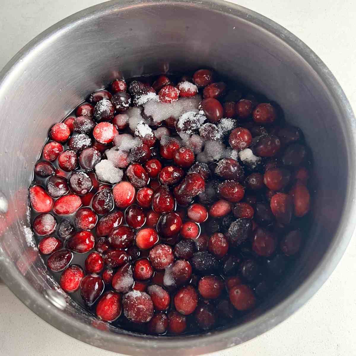 Cranberries, water, and sugar in a pan.