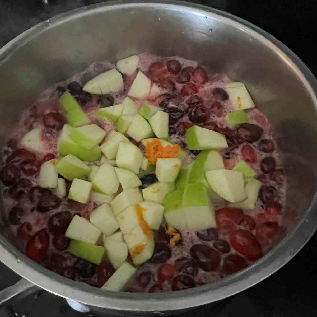 Apples and orange zest cooking with cranberries.