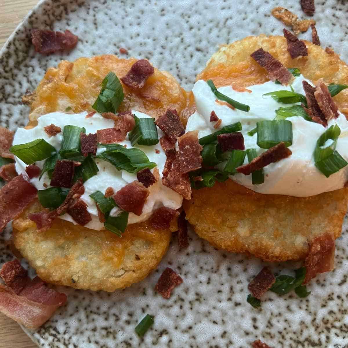 Loaded hash browns topped with yogurt, cheese, and onions.