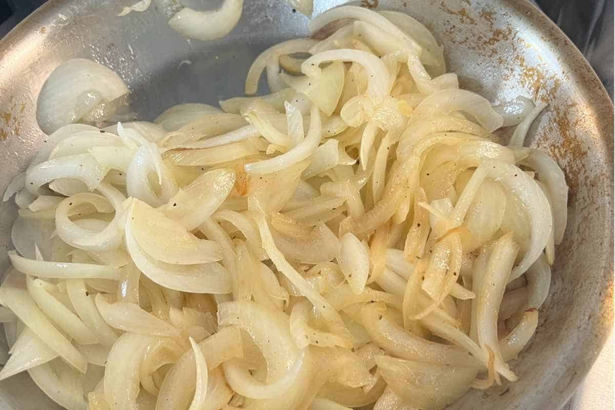 Onions caramelizing in a pan.