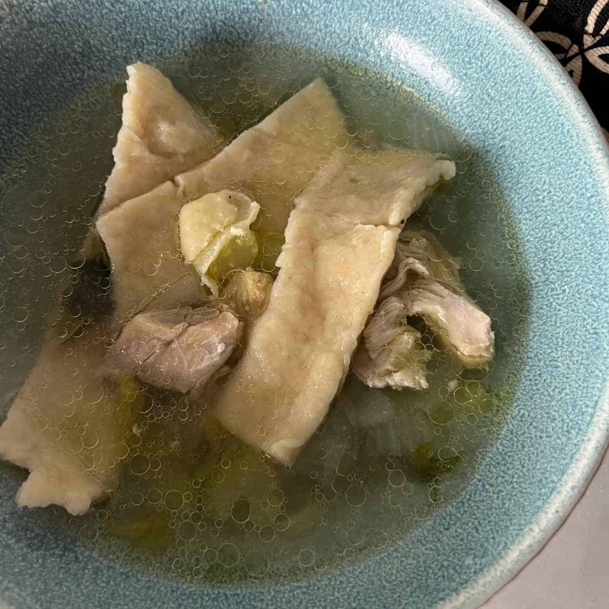 Chicken and Dumplings in a blue bowl ready to eat.