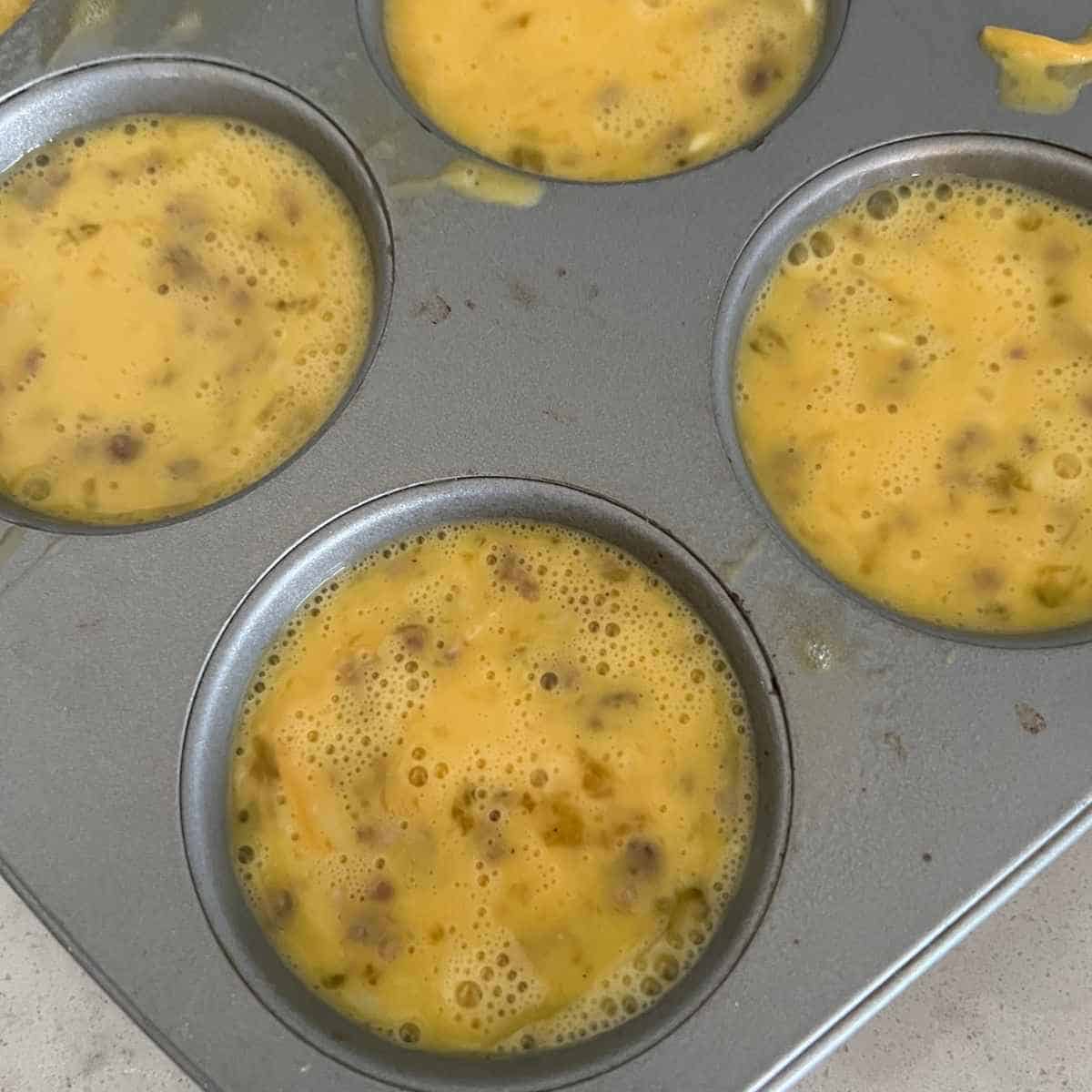Egg mixture in a mini muffin pan. 
