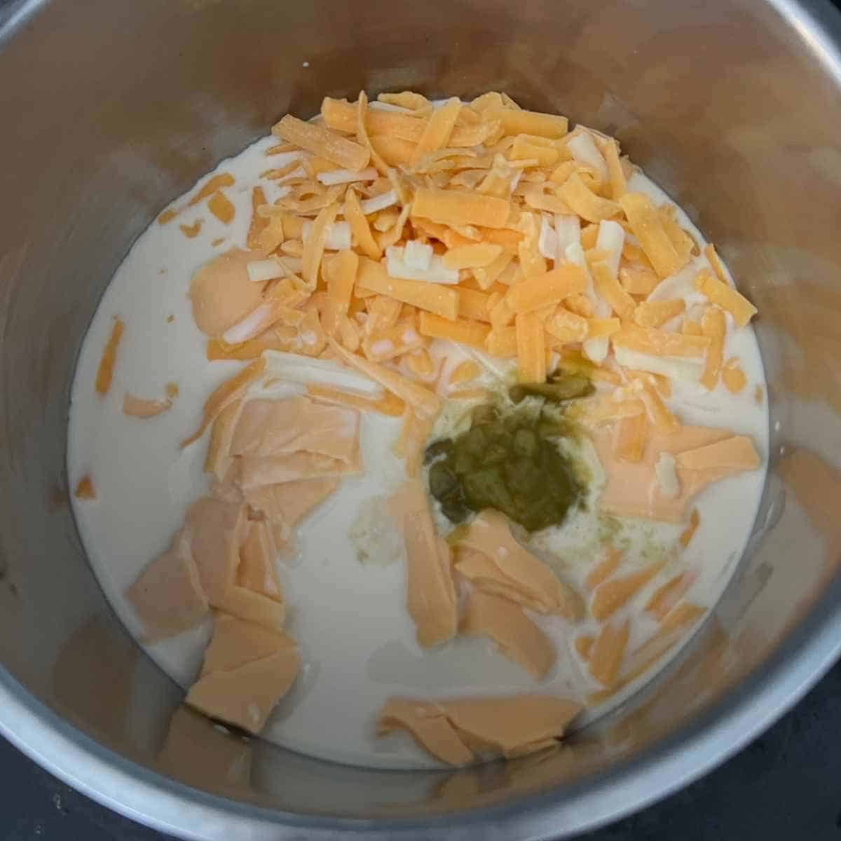 Ingredients combined for nacho cheese sauce in a sauce pan. 