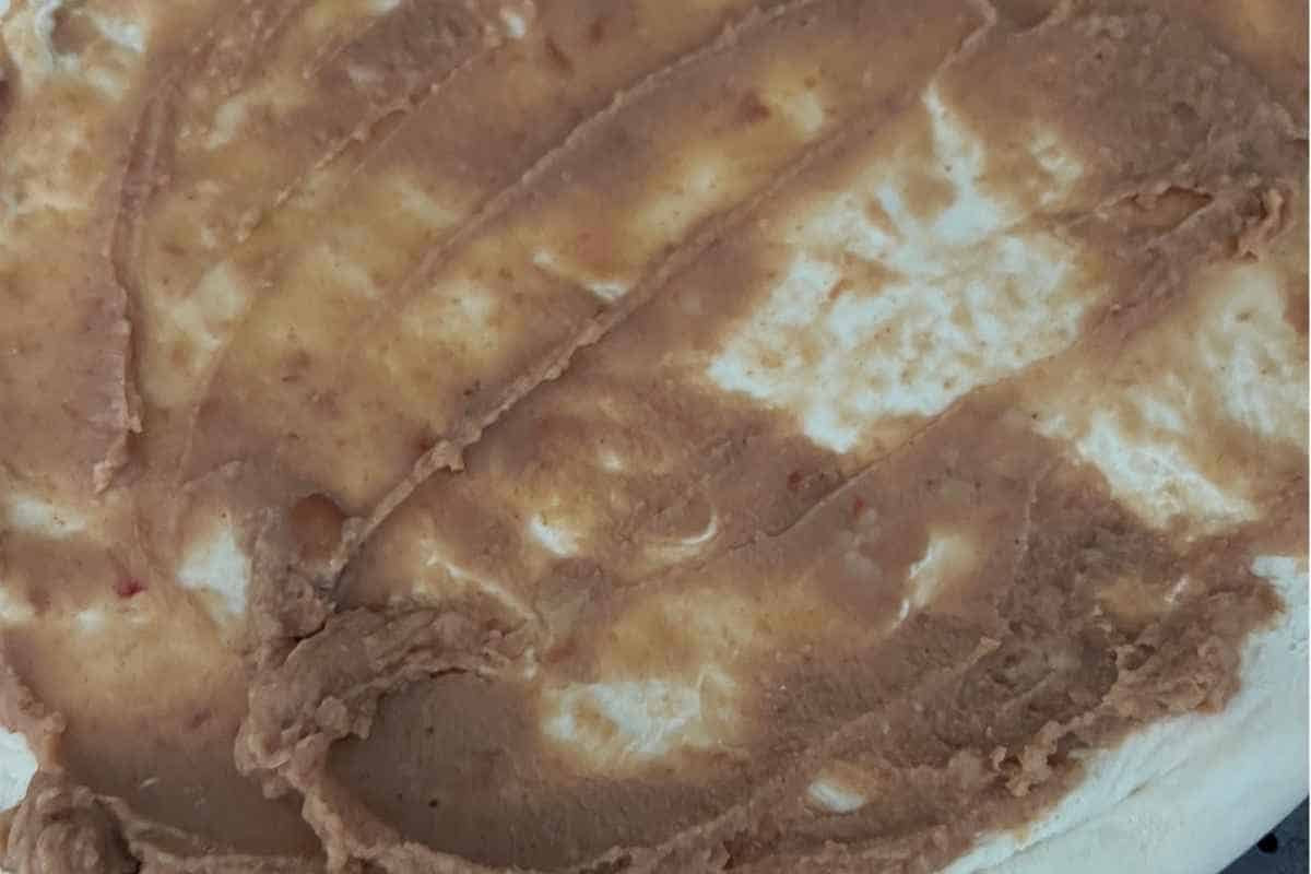Refried beans spread on Taco Pizza. 