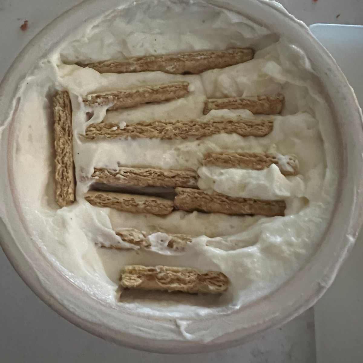 Cup of yogurt with cookies in it.