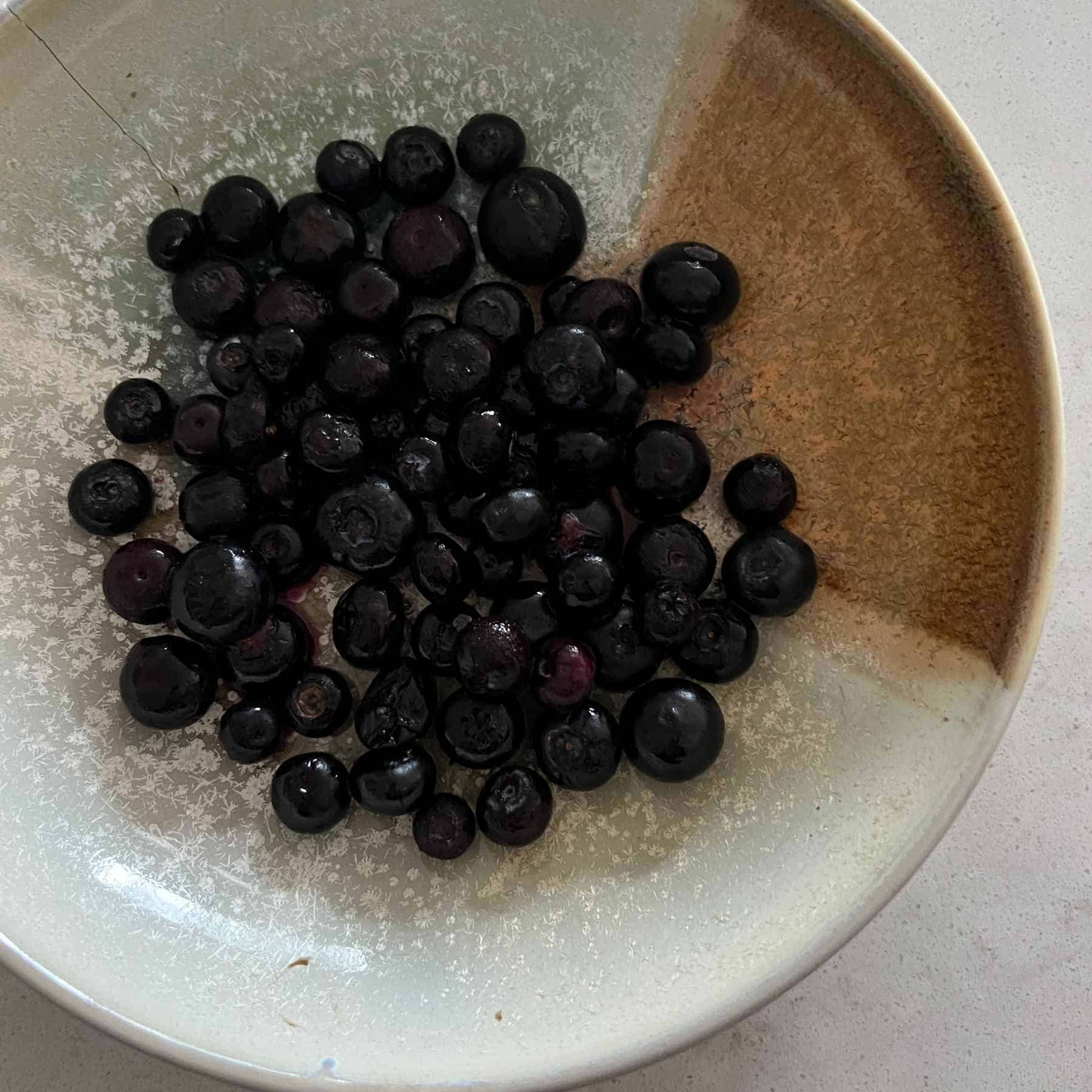 Defrosted blueberries in a bowl. 