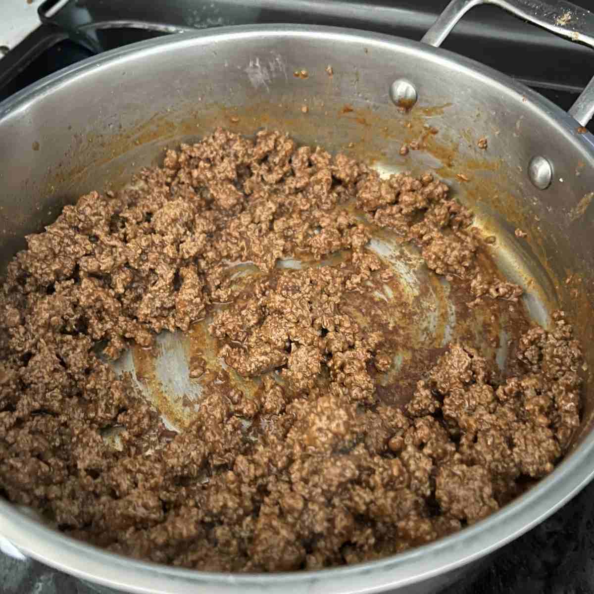 Seasoned cooked ground beef in a pan. 