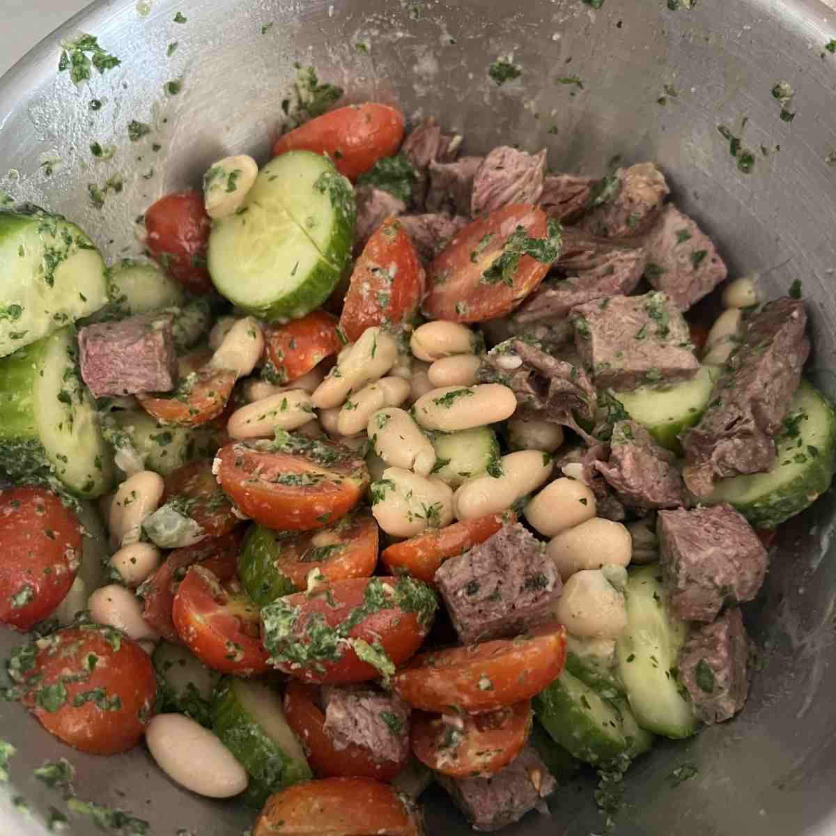 Combined steak chimichurri salad in a bowl.
