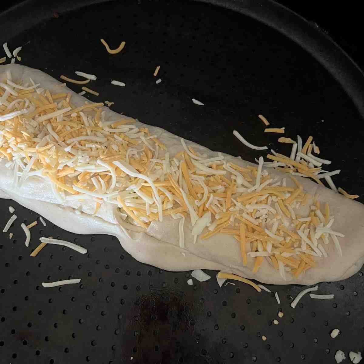 Cheese on top of breadsticks. 