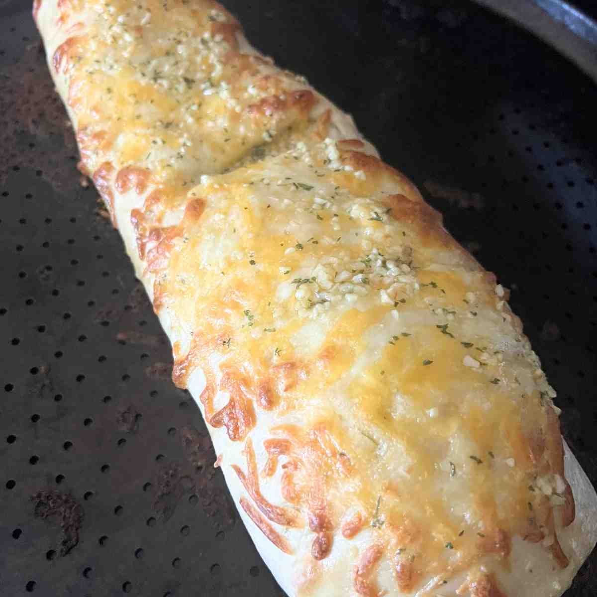 Baked Dominos stuffed cheesy bread topped with garlic and cheese. 