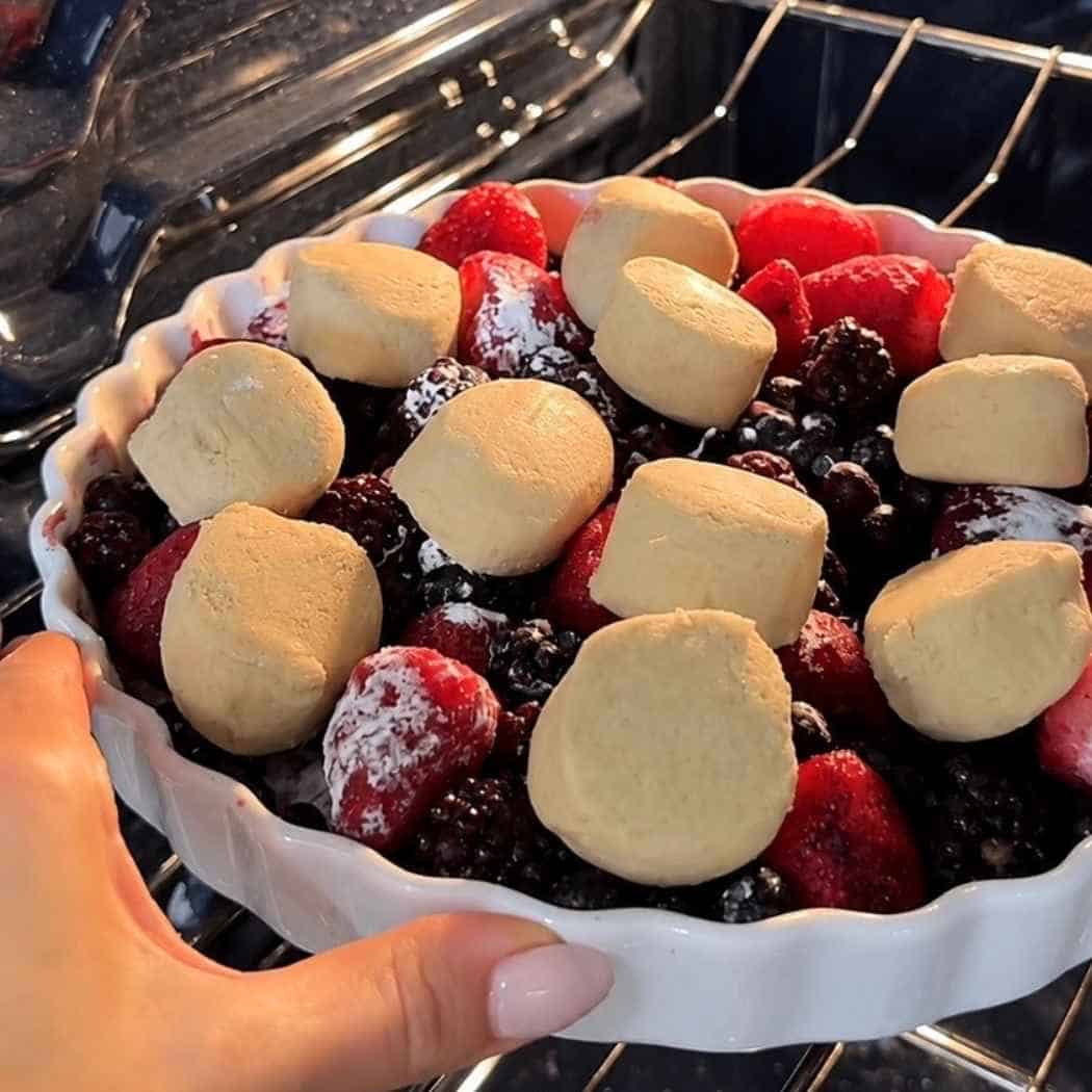 Sugar cookie dough on top of frozen mixed berries. 