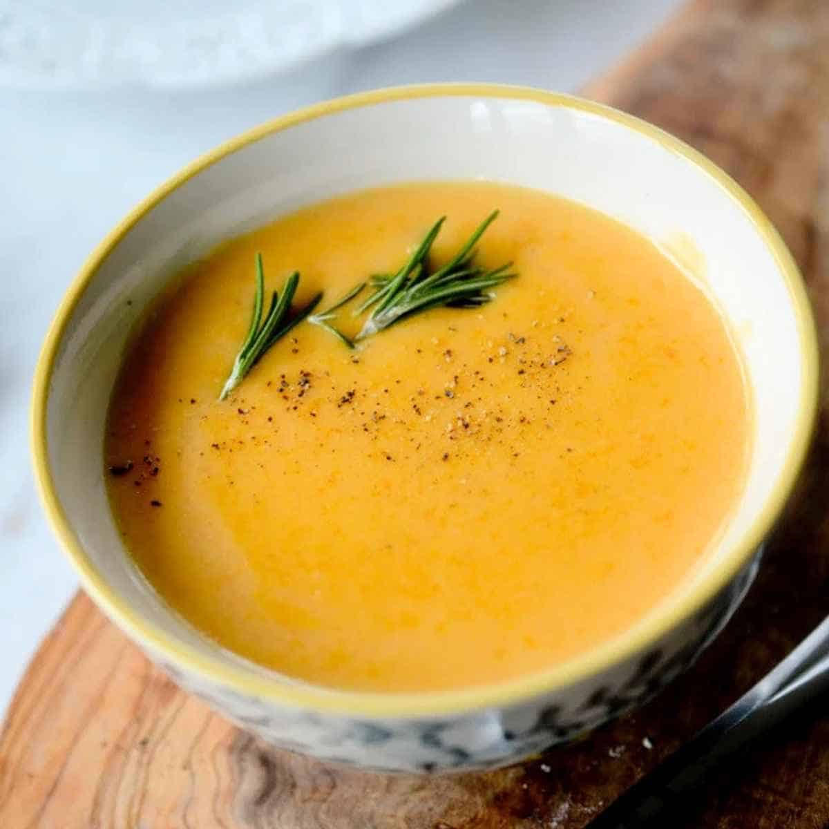 Beer cheese soup garnished with rosemary and pepper.