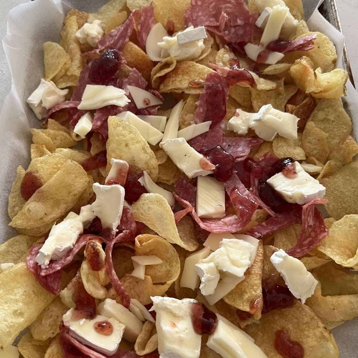 Cheese and salami on top of charcuterie nachos. 