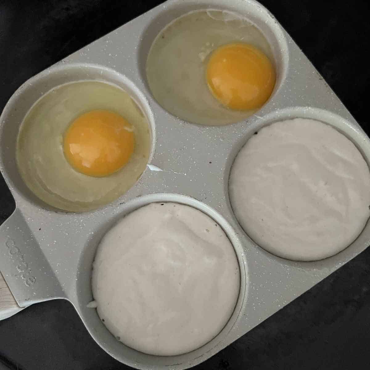 Eggs and pancake mix cooking in a 4 hole pan. 