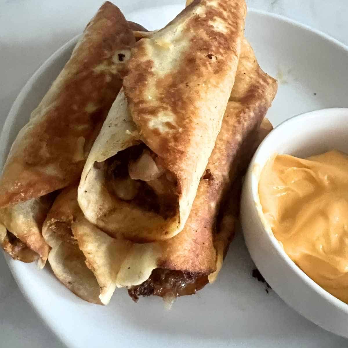 Taco John's Mexi Rolls with a side of cheese.