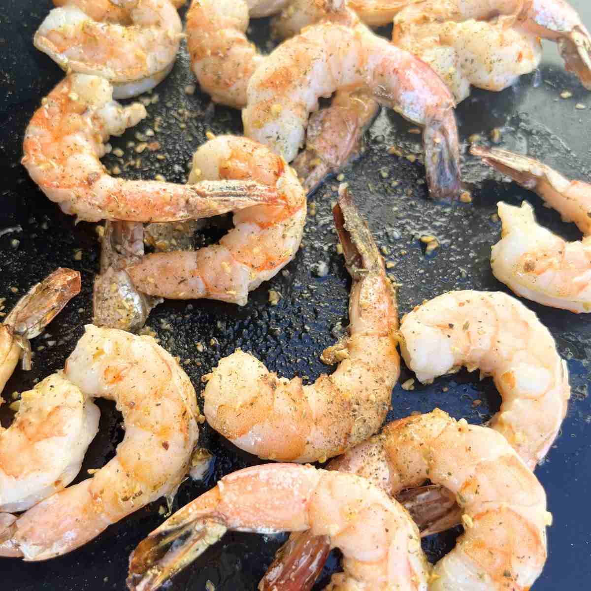 Seasoned cooked shrimp on Blacsktone.