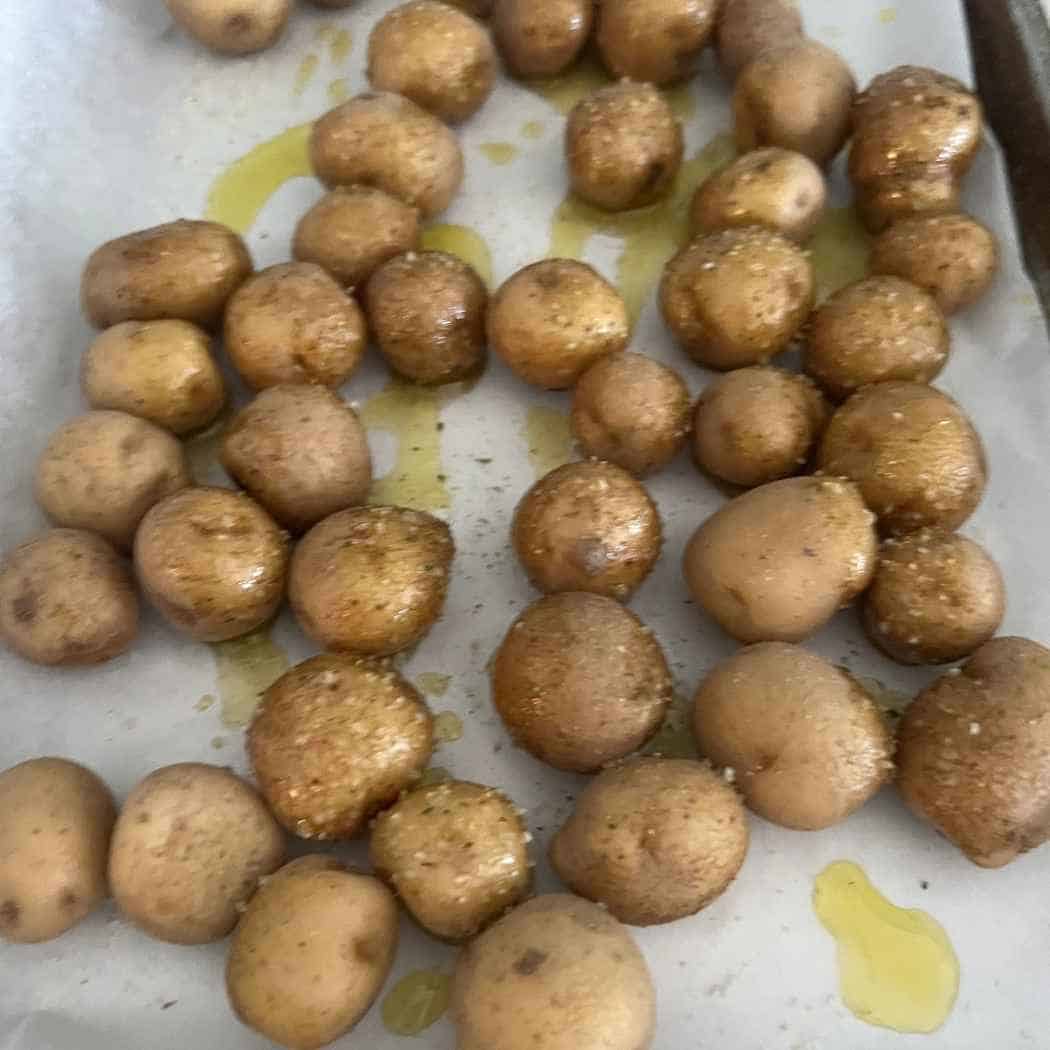 Small yellow potatoes on baking sheet. 