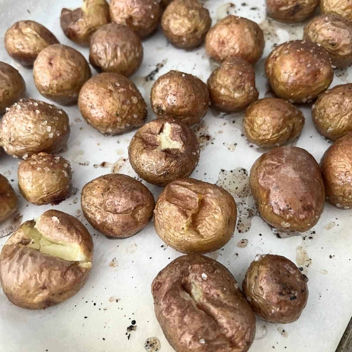 Baked potatoes on baking sheet. 